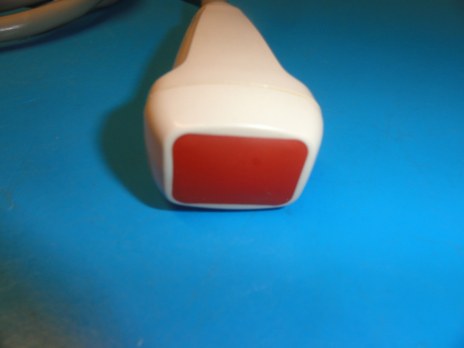 a close up of a red and white object on a blue surface