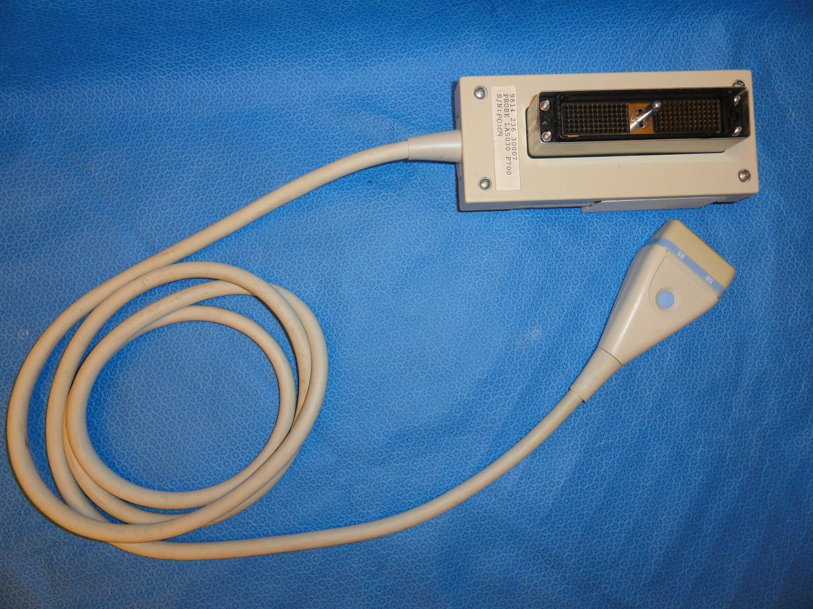 a white cord connected to a device on a blue surface