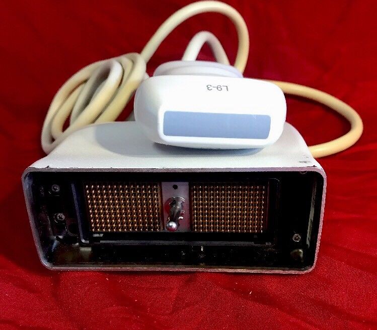 a white electronic device sitting on top of a red blanket